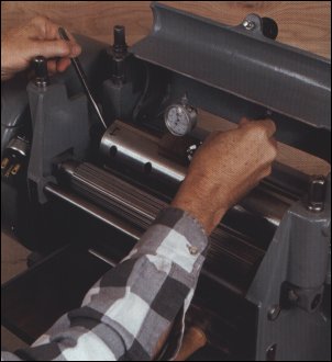 Gauge helps to anticipate knife shift - Using the planer cutterhead as a reference, Vaughan reads the gauge over each setscrew to know whether to raise or lower the knives and to anticipate how much each of the knives will shift during tightening. 